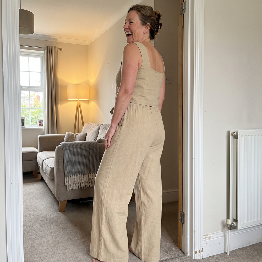 Customer wearing the Megan top and flared trousers set in a living room doorway